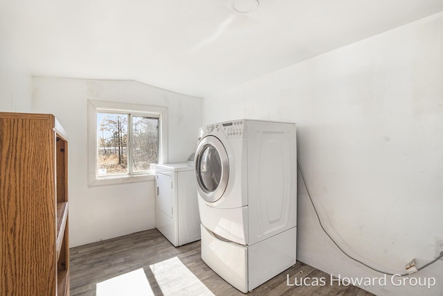 clothes washing area with separate washer and dryer, light wood-style flooring, and laundry area