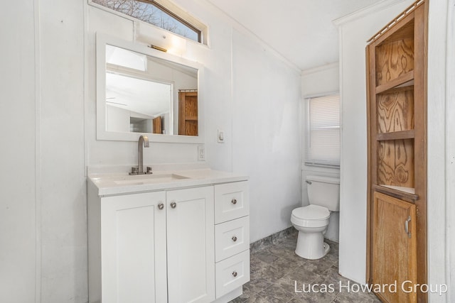 bathroom with toilet, ornamental molding, and vanity