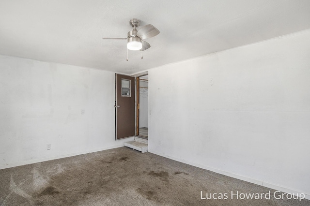 carpeted spare room featuring a ceiling fan