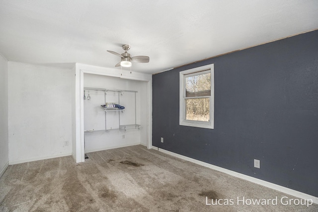 unfurnished bedroom featuring a closet, baseboards, carpet, and a ceiling fan