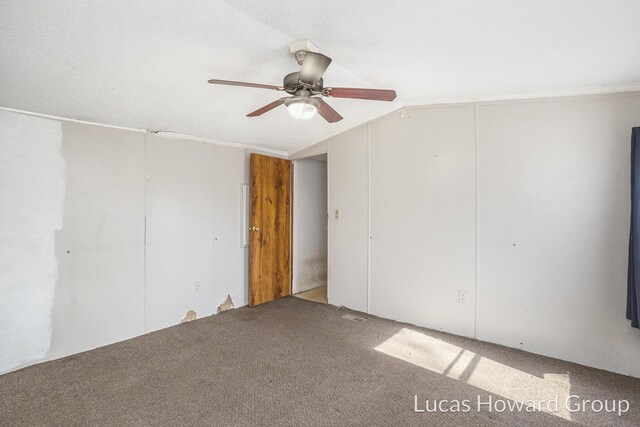 empty room with a ceiling fan, a textured ceiling, carpet flooring, and vaulted ceiling