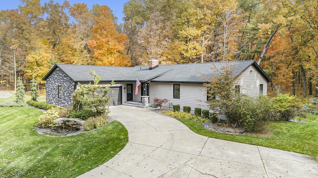 single story home featuring a front yard, roof with shingles, a chimney, a garage, and driveway