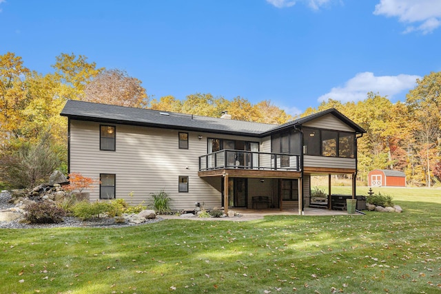 rear view of property featuring a patio, an outbuilding, a yard, a sunroom, and a storage shed