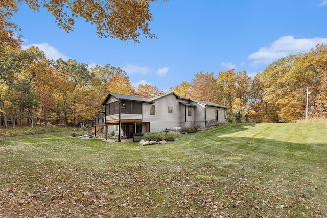 rear view of house featuring a patio area, a yard, and a sunroom