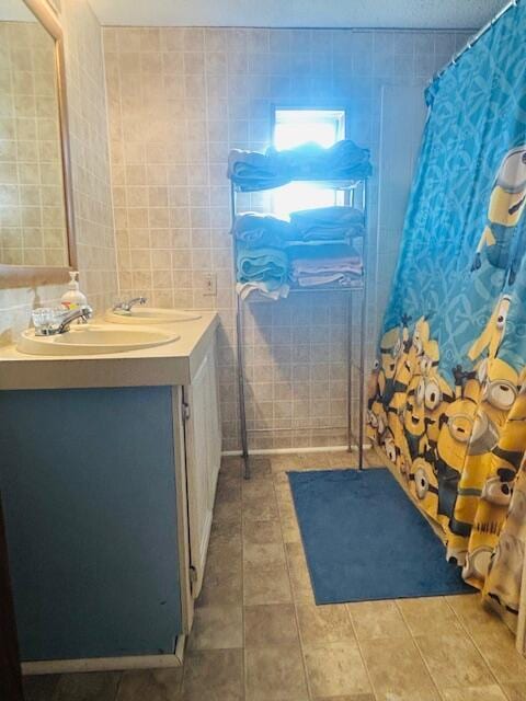 bathroom featuring tile patterned floors, a shower with shower curtain, tile walls, and vanity