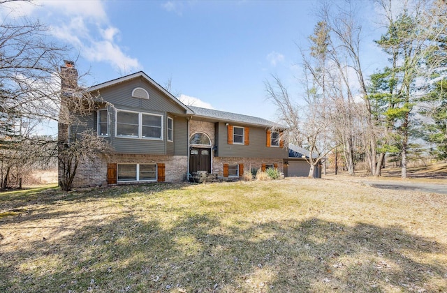 split foyer home with a front lawn, brick siding, a garage, and a chimney