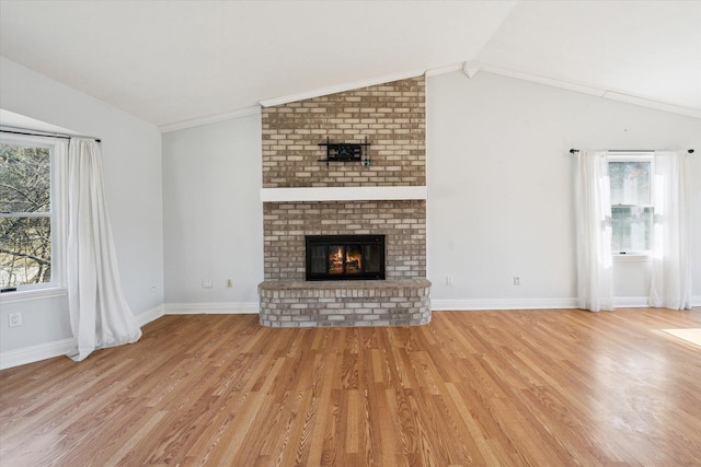 unfurnished living room featuring light wood-style flooring, a fireplace, baseboards, and lofted ceiling