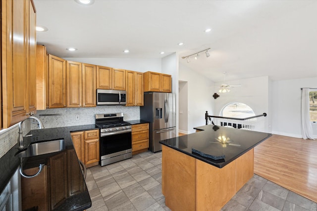 kitchen featuring a sink, backsplash, dark countertops, stainless steel appliances, and lofted ceiling