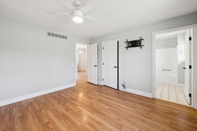 unfurnished bedroom featuring light wood-type flooring, visible vents, a ceiling fan, ensuite bathroom, and baseboards