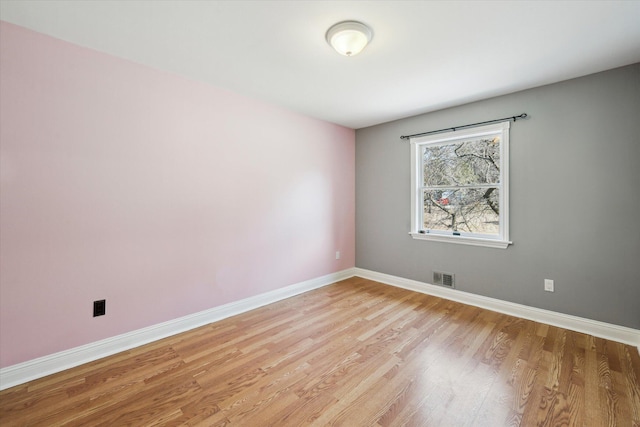 spare room with visible vents, baseboards, and light wood-style floors