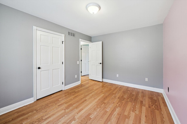 unfurnished bedroom with light wood-style floors, baseboards, and visible vents