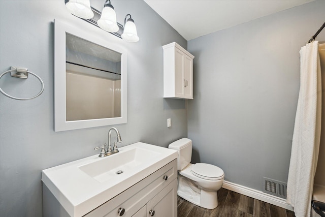 full bathroom with visible vents, baseboards, toilet, wood finished floors, and vanity