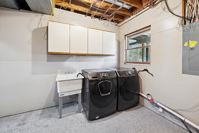 laundry area featuring electric panel, cabinet space, independent washer and dryer, and a sink