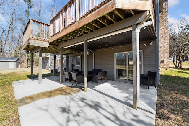 view of patio with an outdoor structure, a storage shed, a deck, and outdoor lounge area