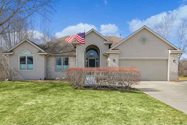 view of front of property with driveway, brick siding, an attached garage, and a front lawn