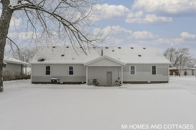 view of snow covered back of property