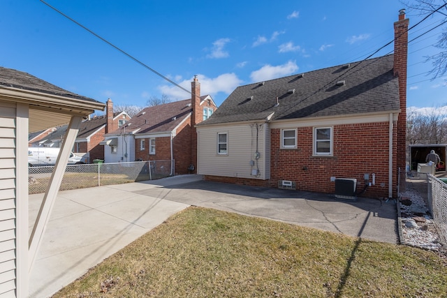 rear view of house with a patio area, cooling unit, brick siding, and fence