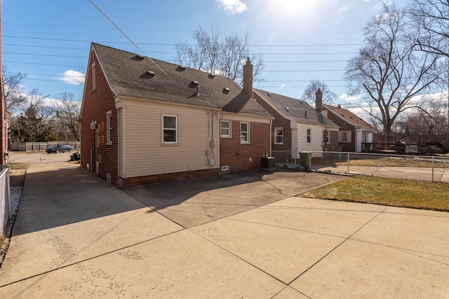 exterior space with a patio, fence, driveway, a chimney, and central air condition unit