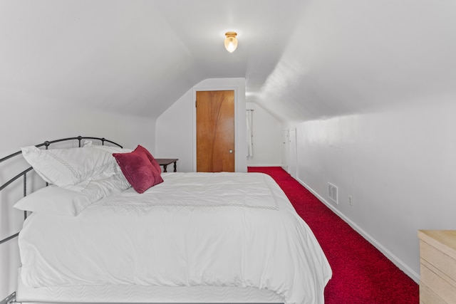 bedroom featuring carpet flooring, visible vents, baseboards, and lofted ceiling