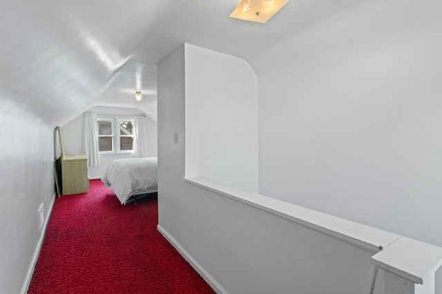 carpeted bedroom with baseboards and vaulted ceiling