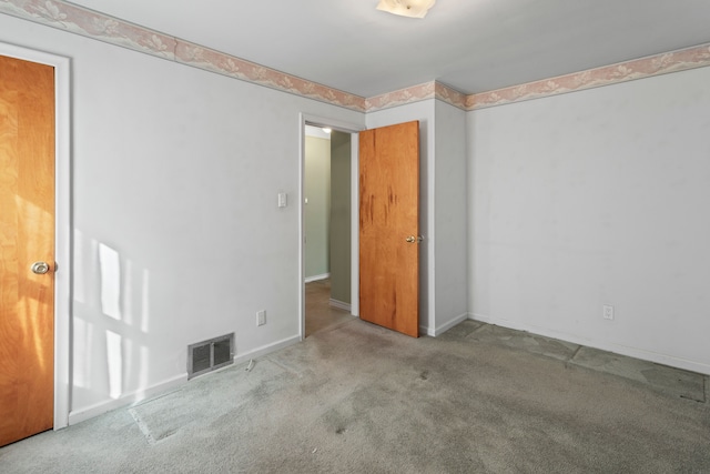 unfurnished bedroom with visible vents, carpet flooring, and baseboards