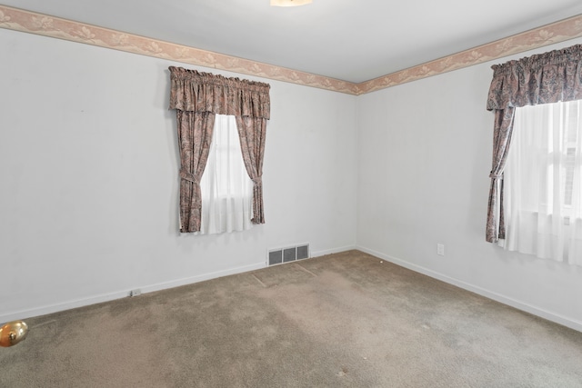 unfurnished room featuring visible vents, plenty of natural light, baseboards, and carpet floors