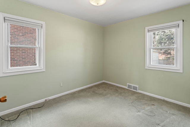 carpeted spare room with baseboards and visible vents