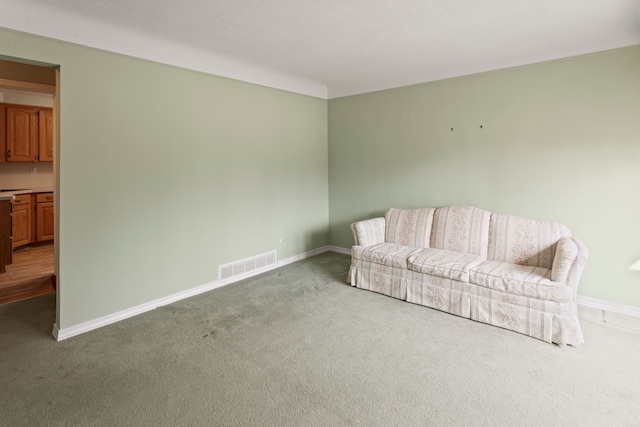 sitting room with visible vents, carpet floors, and baseboards