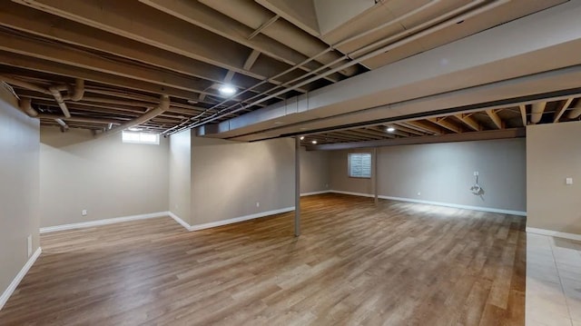 below grade area with wood finished floors and baseboards