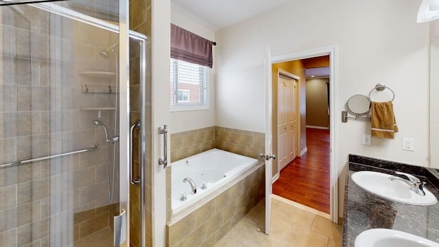 full bathroom with tile patterned flooring, a shower stall, a whirlpool tub, double vanity, and a sink