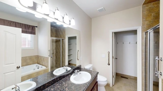 bathroom with a sink, a walk in closet, visible vents, and a stall shower