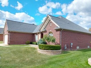 view of side of home featuring brick siding and a lawn