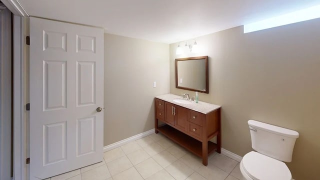 bathroom with vanity, toilet, baseboards, and tile patterned flooring