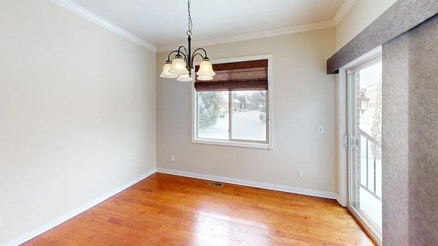 empty room with baseboards, visible vents, an inviting chandelier, ornamental molding, and light wood-type flooring