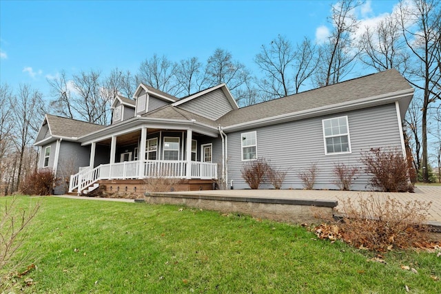 view of front of property featuring a front yard, a porch, and roof with shingles