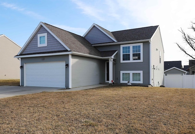 view of front of home with fence, roof with shingles, concrete driveway, a front lawn, and a garage