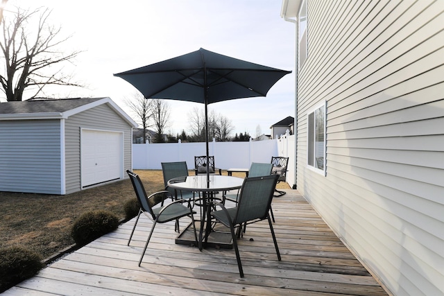 deck featuring an outdoor structure, outdoor dining area, and fence