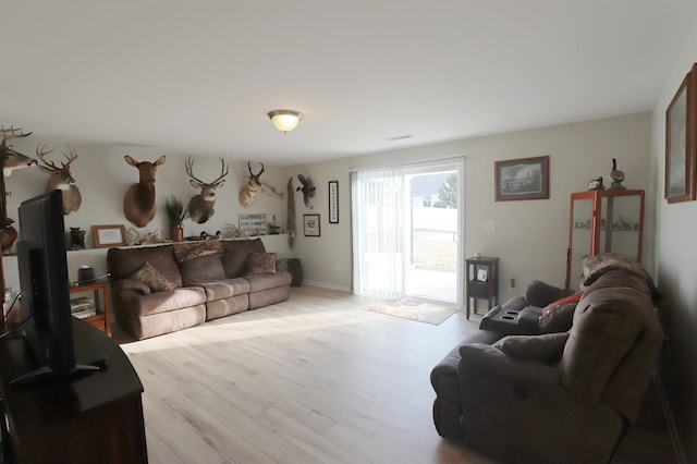 living area with visible vents and wood finished floors