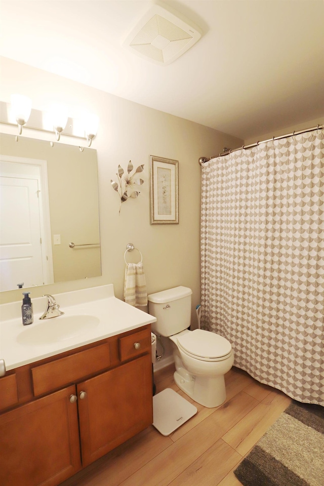 full bathroom featuring visible vents, toilet, a shower with curtain, wood finished floors, and vanity