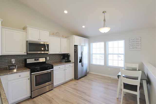 kitchen with light wood-type flooring, white cabinetry, appliances with stainless steel finishes, decorative backsplash, and vaulted ceiling