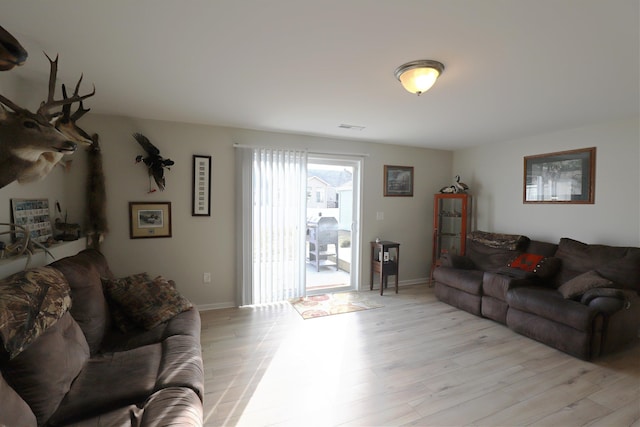 living area with visible vents, baseboards, and light wood-style floors