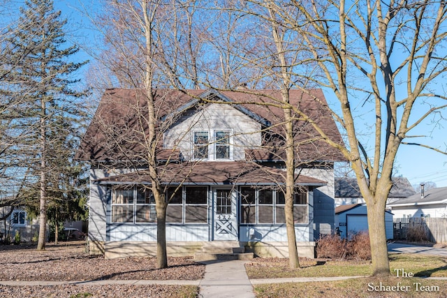 view of front facade with fence and a sunroom