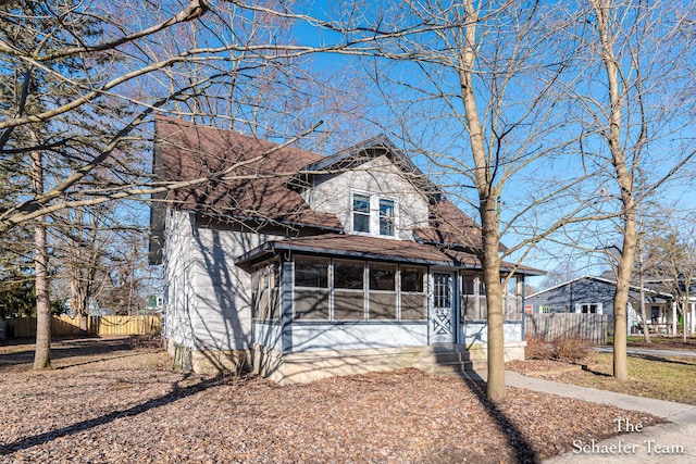 view of front of home featuring fence and a sunroom