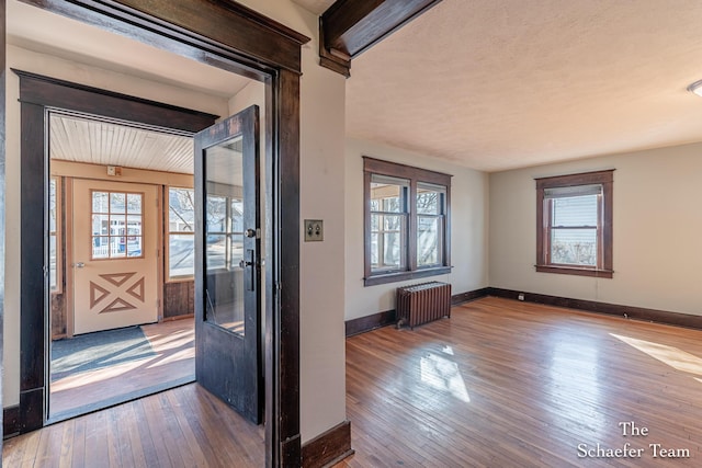 entryway with radiator, baseboards, and hardwood / wood-style floors