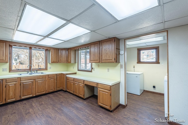 kitchen with a sink, dark wood-type flooring, refrigerator, and light countertops