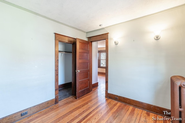 bedroom with baseboards, light wood-style floors, and ornamental molding