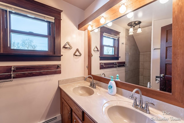 bathroom featuring double vanity, a baseboard heating unit, and a sink