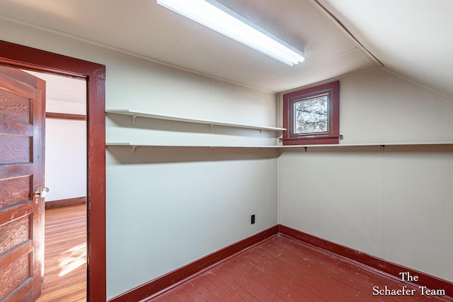 interior space featuring vaulted ceiling, baseboards, and hardwood / wood-style flooring