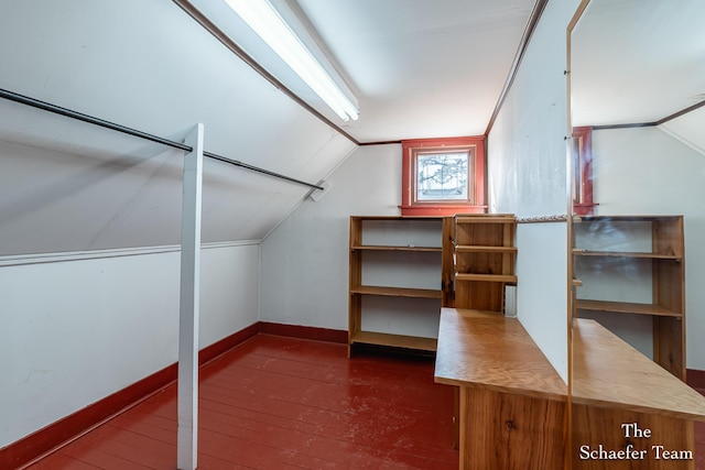 additional living space with dark wood-style floors, baseboards, and lofted ceiling