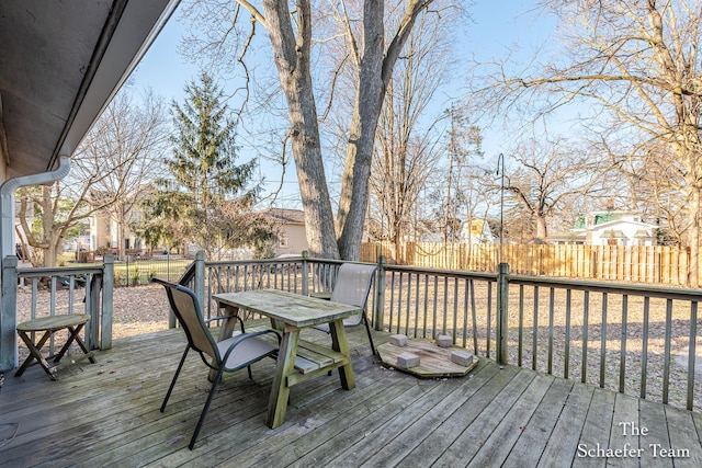 wooden deck featuring a fenced backyard, a residential view, and outdoor dining space